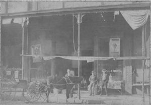 1895  Ernest Jesse Palmer standing behind his father's team of horses ready to deliver groceries in Webb City, Missouri